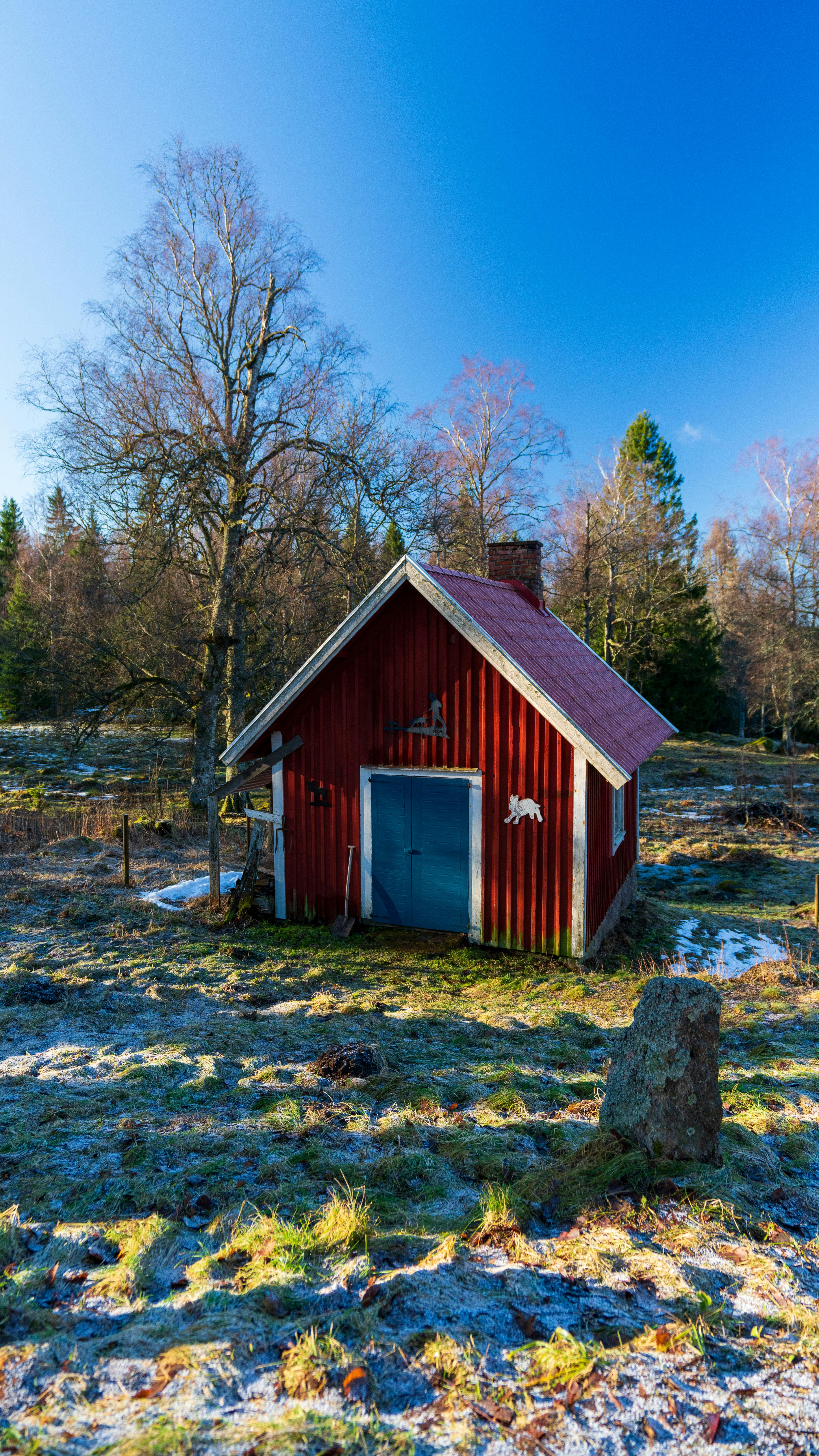 Liten rød bod i hagen om vinteren